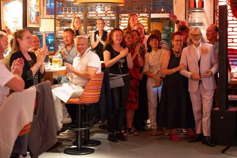 Eine Gruppe von Gästen applaudiert und lächelt nach der Show im Restaurant.