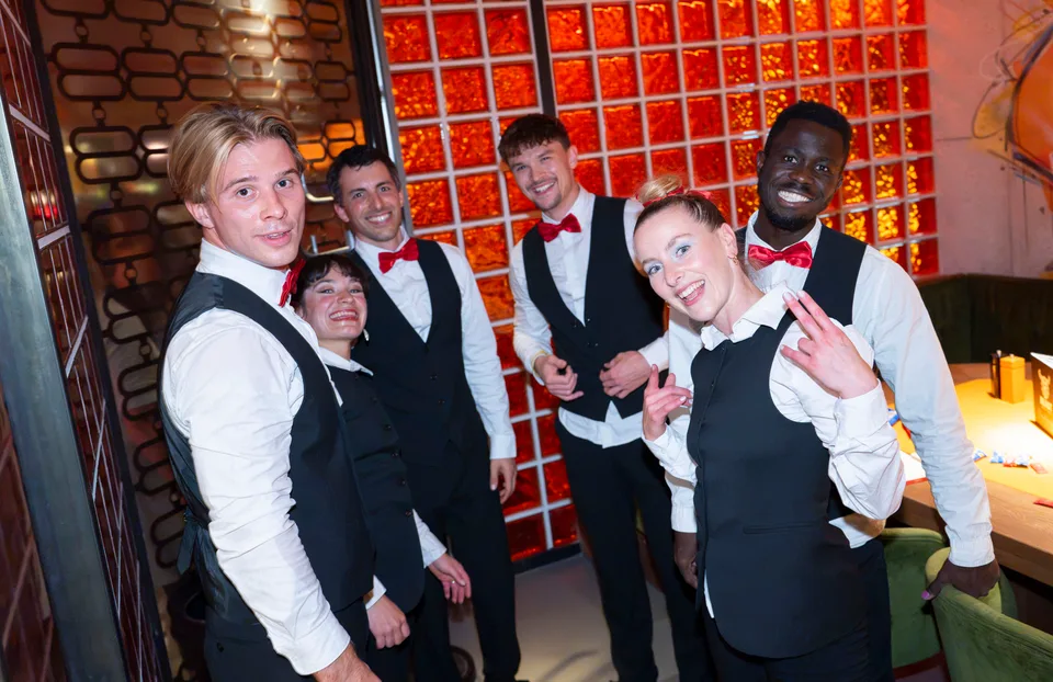 Das Show-Waiters-Team im Kellner-Outfit gemeinsam nach einem Auftritt.