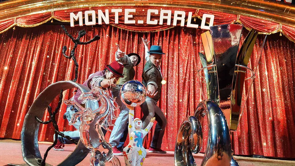 Drei Künstler von The Funky Monkeys posieren zwischen Trophäen vor einem roten Vorhang mit Monte-Carlo-Schriftzug.